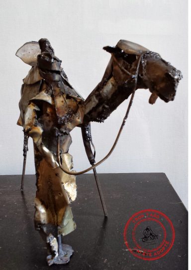 Compagnon du désert Sculpture en métal représentant un homme méhari debout à côté de son dromadaire, tous deux façonnés en acier.