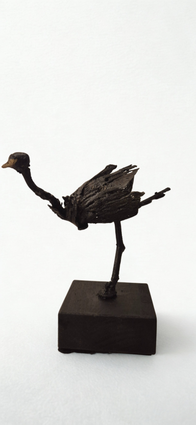 Le petit rat de l'opéra autruche en acier noirci et bec en or. Elle lève une pate en arrière comme un petit rat d'Opera.